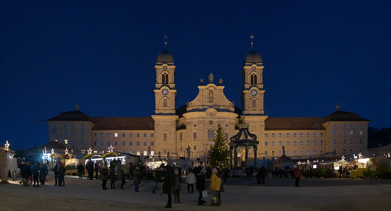 Klosterplatz at night: illuminated abbey, Christmas tree, Marienbrunnen and market stalls with stars of light (2019)