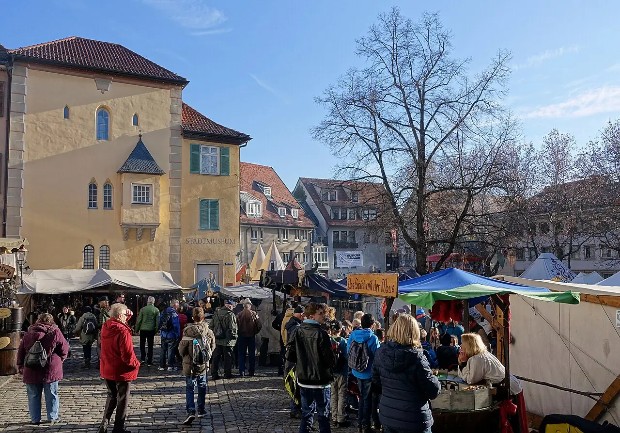 Tents and stalls of the medieval market in front of the Stadtmuseum im Gelben Haus on Hafenmarkt, by day