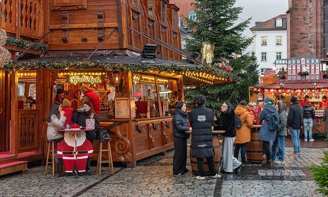 Wooden huts and Christmas tree on Marktplatz, the Heiliggeistkirche on the right, in the late afternoon
