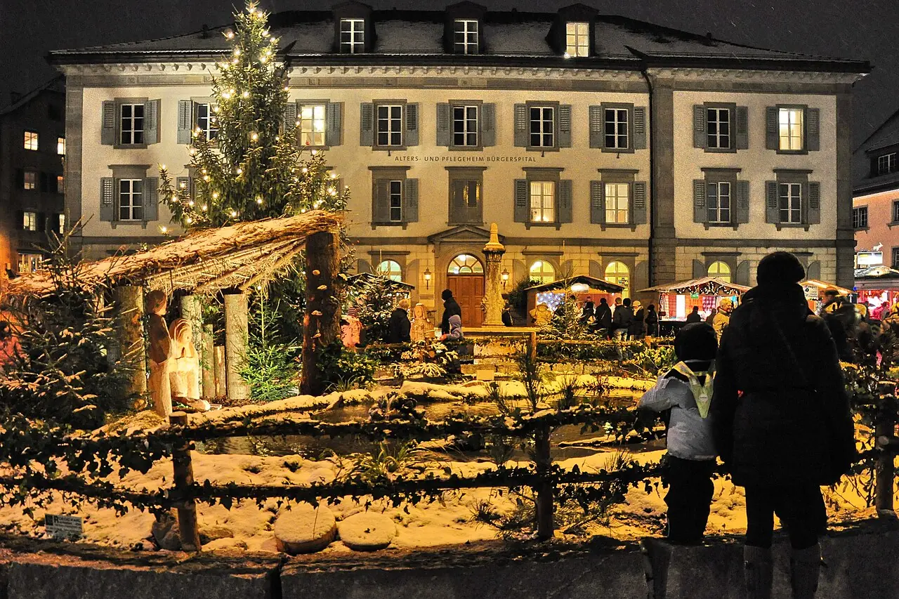Nativity scene with wooden figures and a Christmas tree on Fischmarktplatz in front of the Bürgerspital, in the evening with snow (2010)
