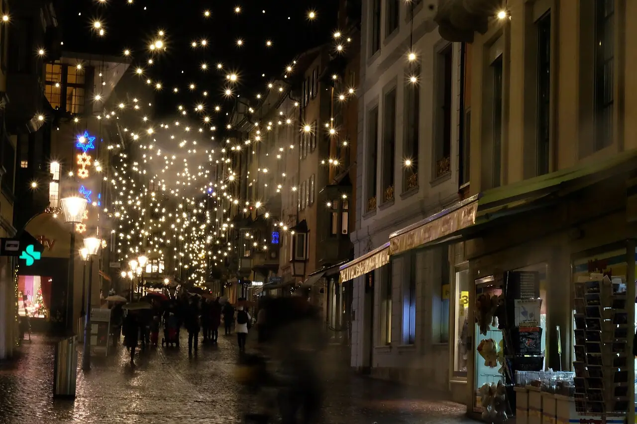 Sky of lights above Vordergasse in the evening, passers-by with umbrellas (Advent 2018)