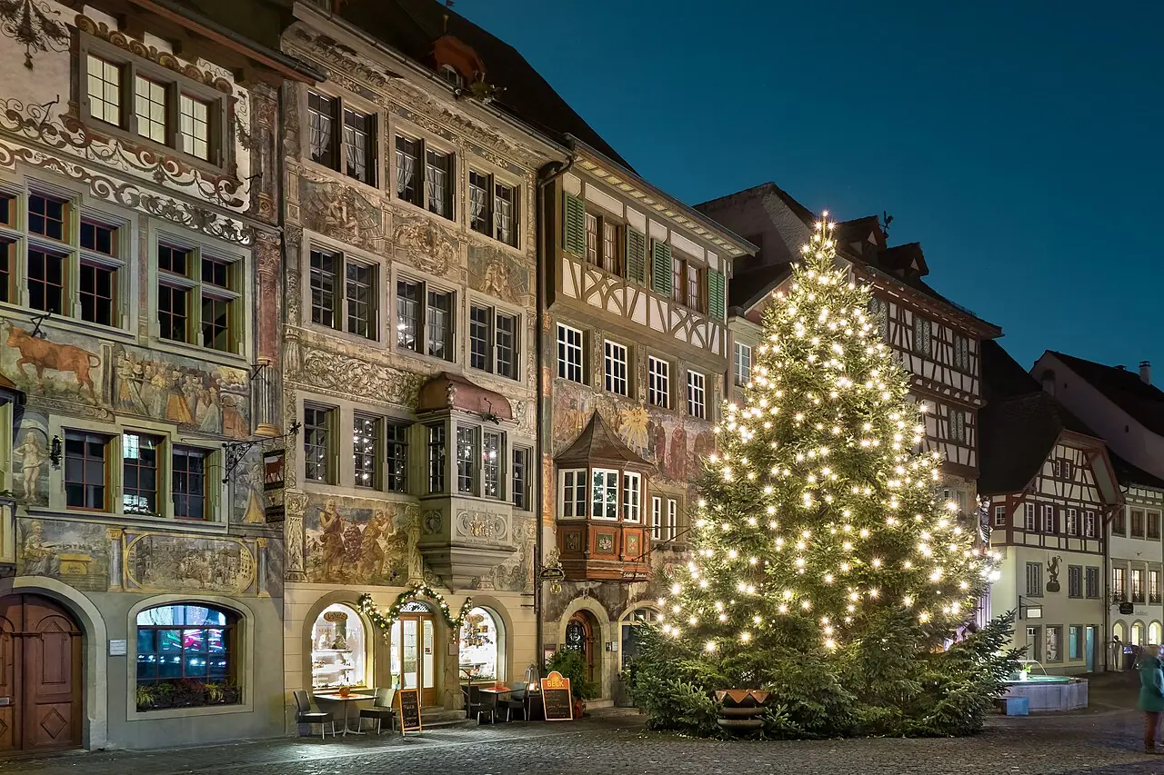 Illuminated Christmas tree in front of the painted façades on Rathausplatz at the blue hour (December 2016)