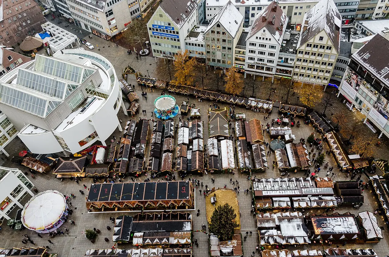 View from the Minster tower over the town of stalls on Münsterplatz with carousel and Christmas tree